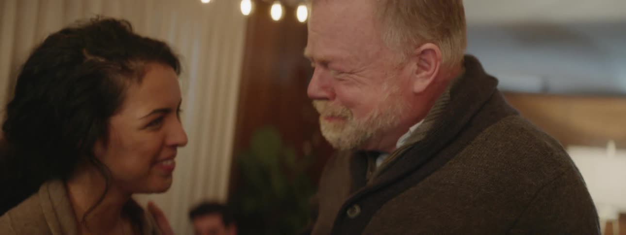 A man and woman embrace at a party