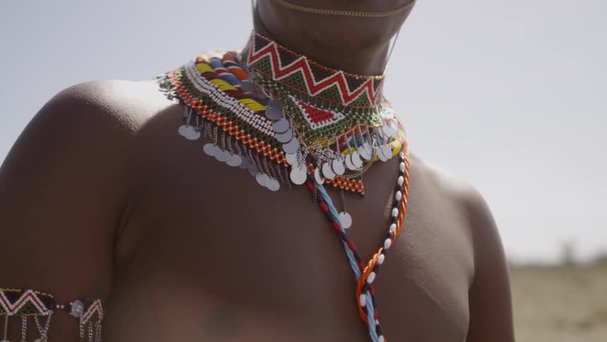 A man wears traditional tribal necklace and arm band