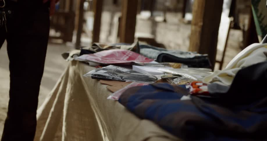 A vendor is selling clothes outside in daylight