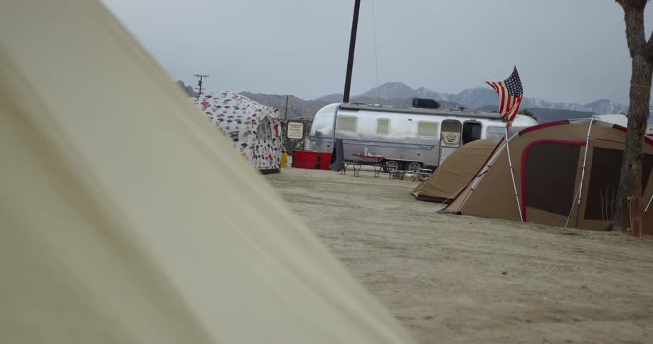 There are trailers and tents set on the field