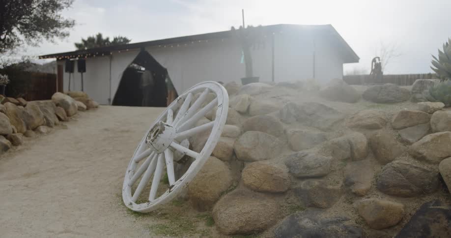 Wagon wheel leans against a pile of rocks
