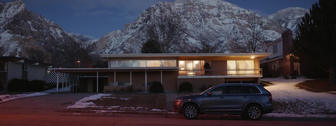 Two people walk up front stairs to a house and go inside