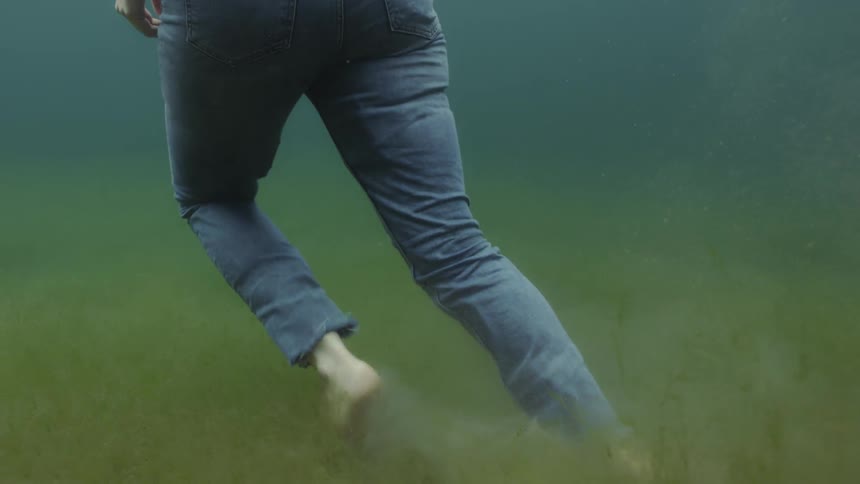 A woman walks underwater