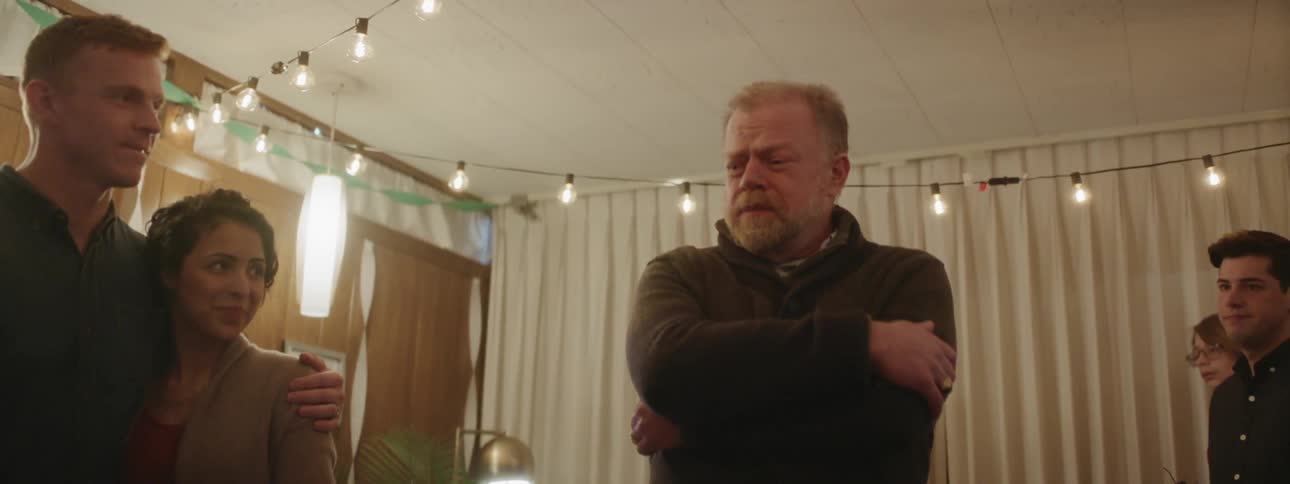 A man looks around talking at a party