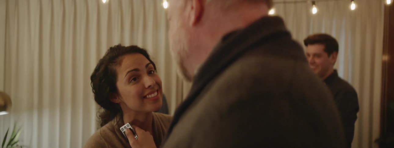 A man and woman talk and laugh at a party