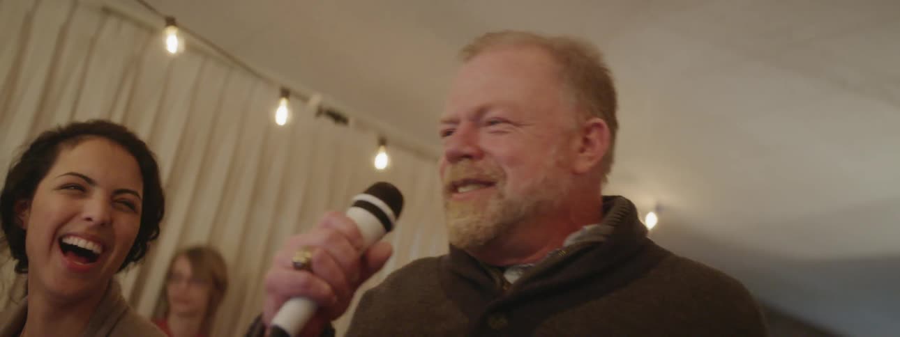 A man sings karaoke at a party