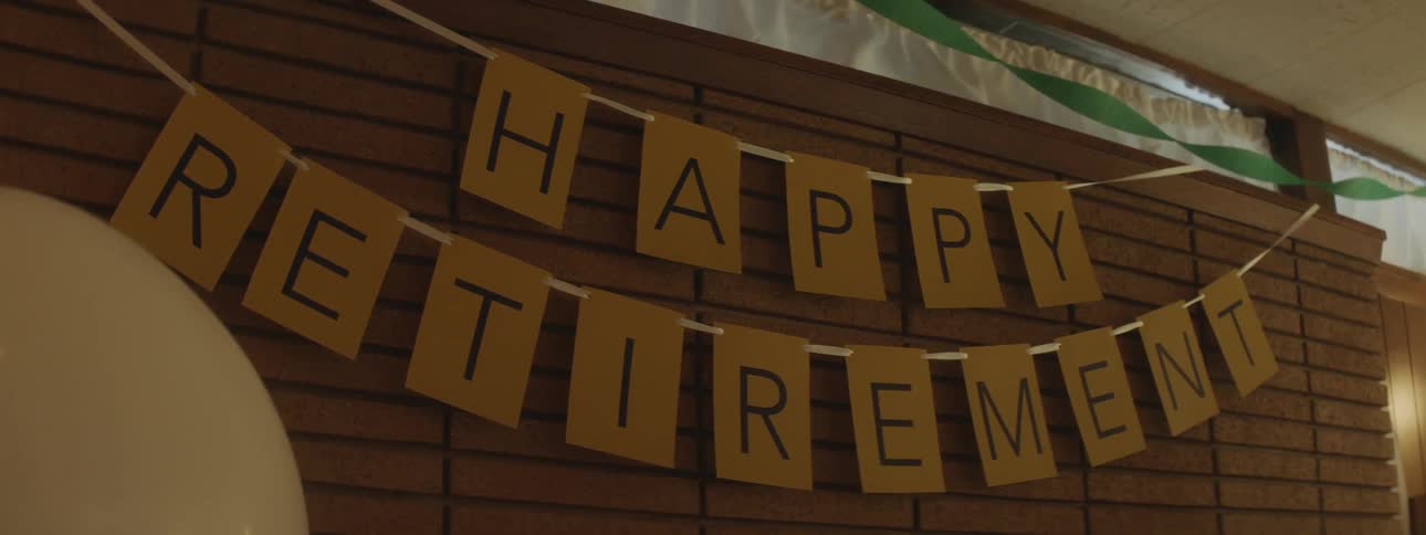 A happy retirement banner hands on a wall