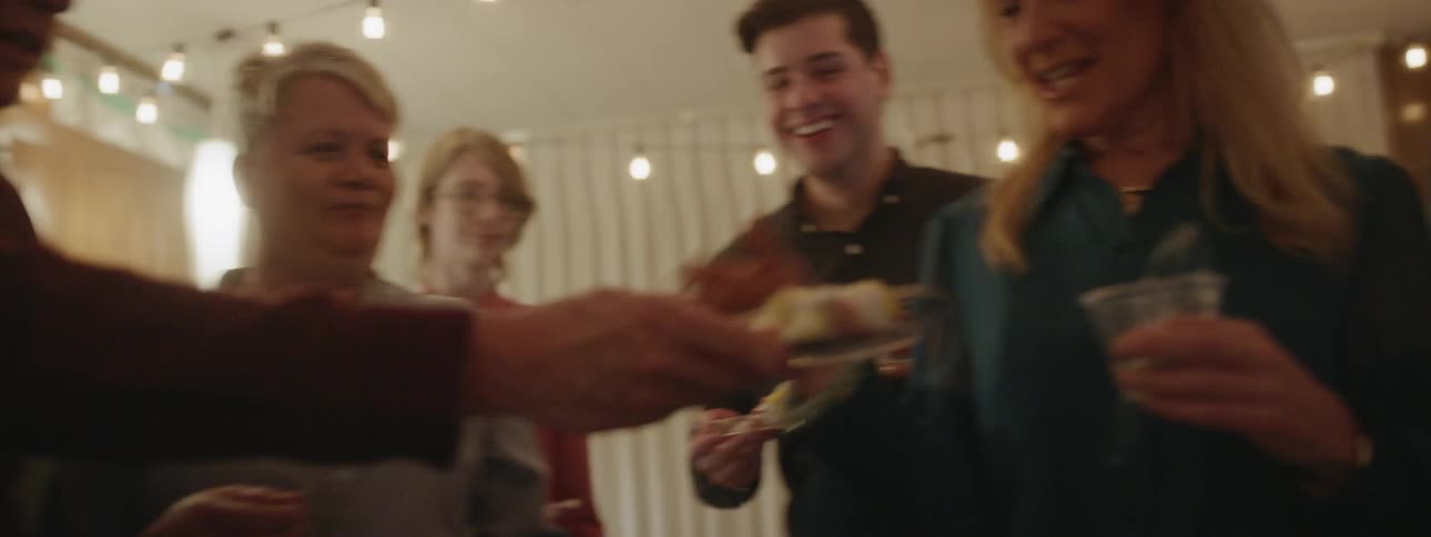 A man passes out cakes to party goers