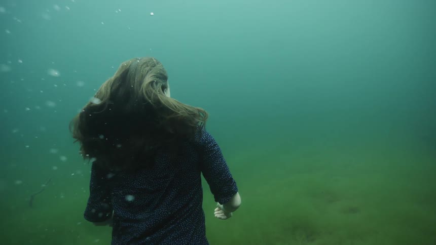 A woman walks on the bottom of the water