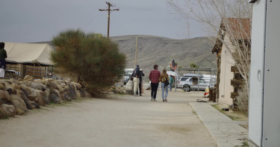 Man and woman walk down a street towards a parking lot