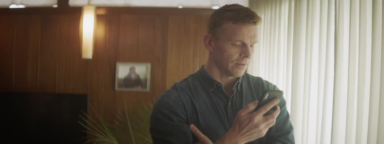 Man stands in a room talking on a phone