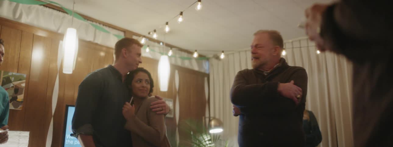 People stand together talking and smiling at a party
