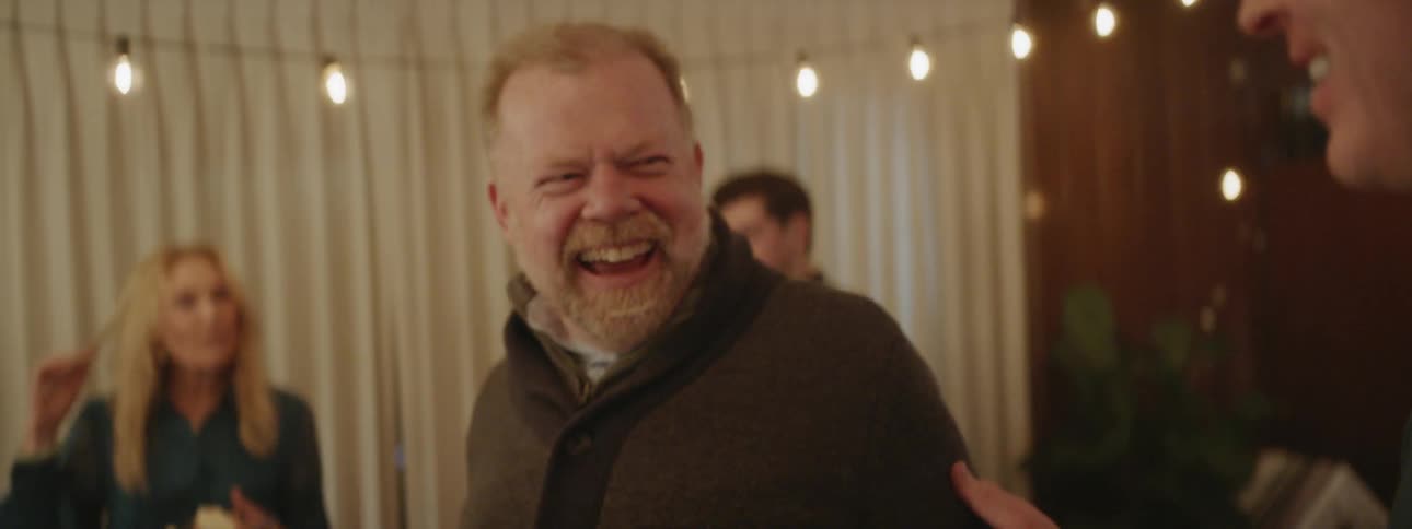Man laughs as another man talks to him