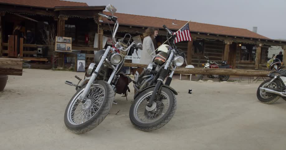 Motorcycles are parked in front of a log cabin