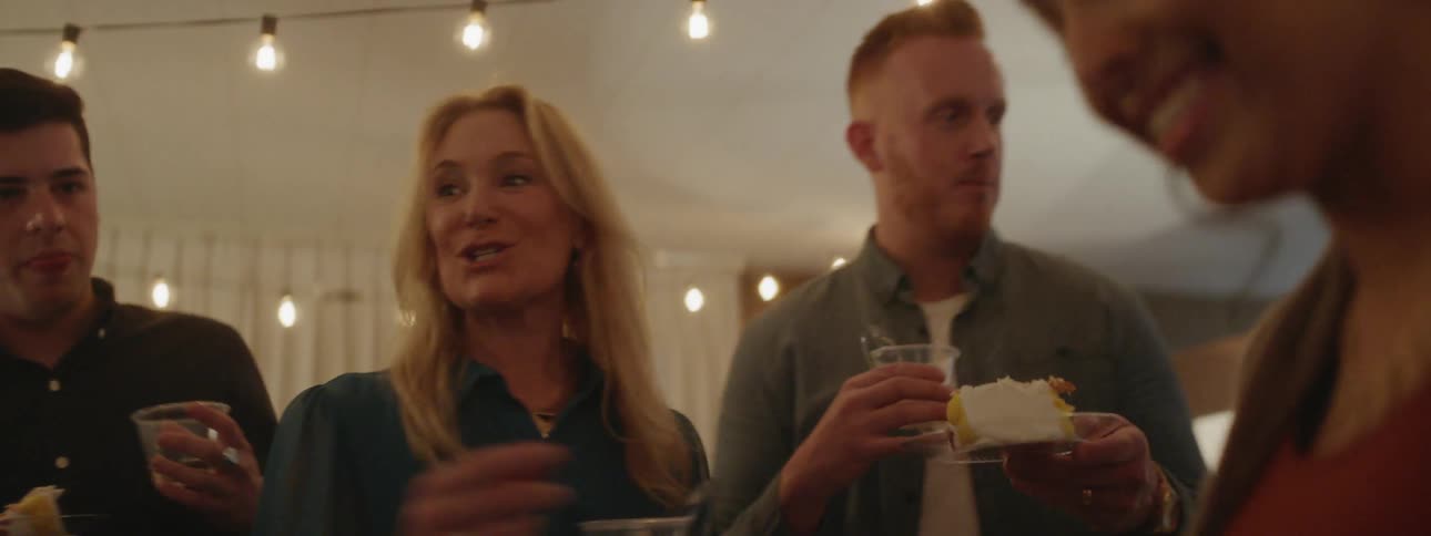 People serve cake and talk at a party