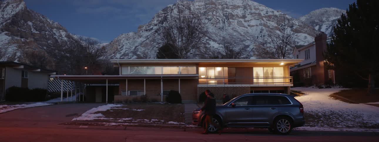 Two men exit a vehicle and walk towards a house