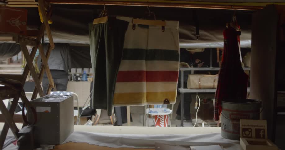 Blankets hang from a pole in a market building