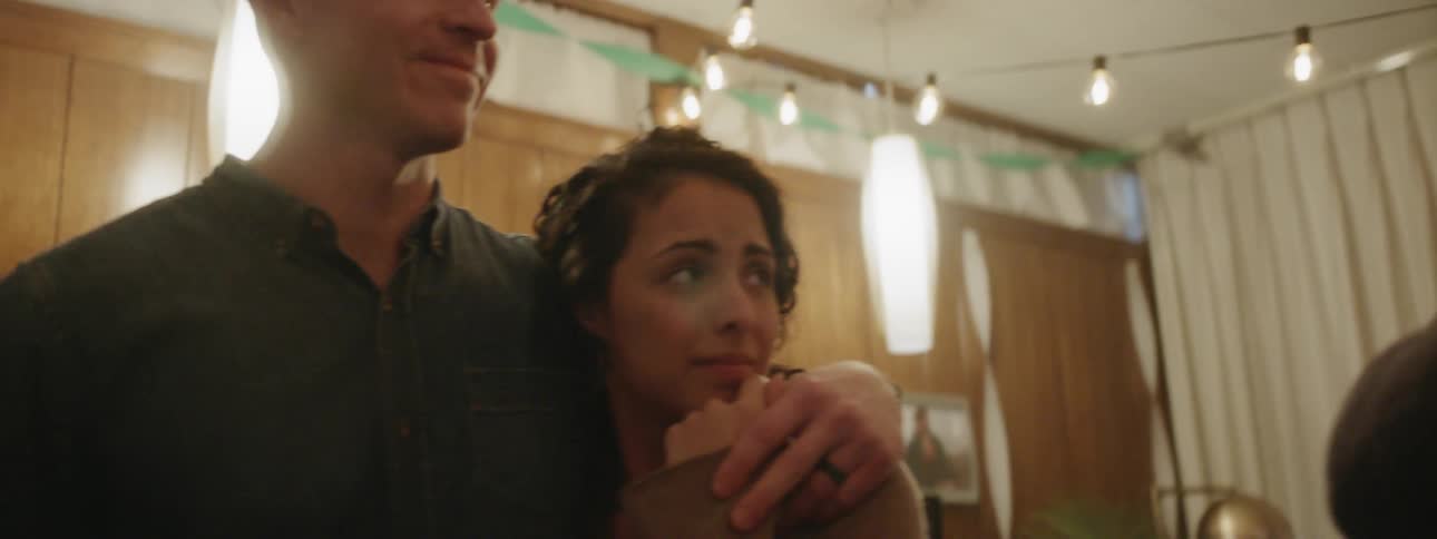 Three people talk at a house party