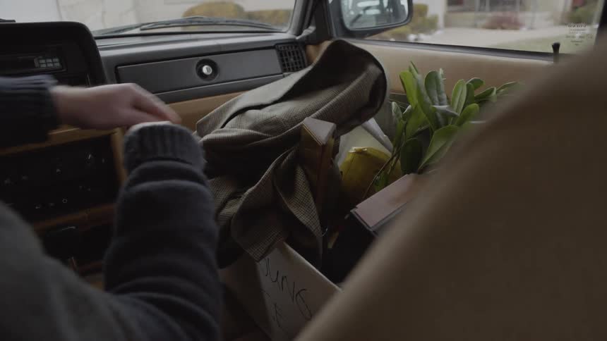 Man picks up a box of belongings inside a car