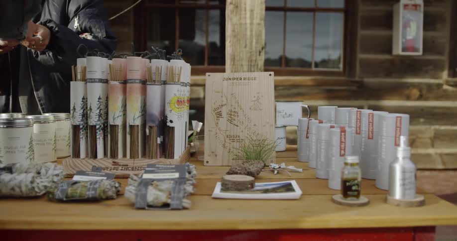Person hands another person something behind a stand of products