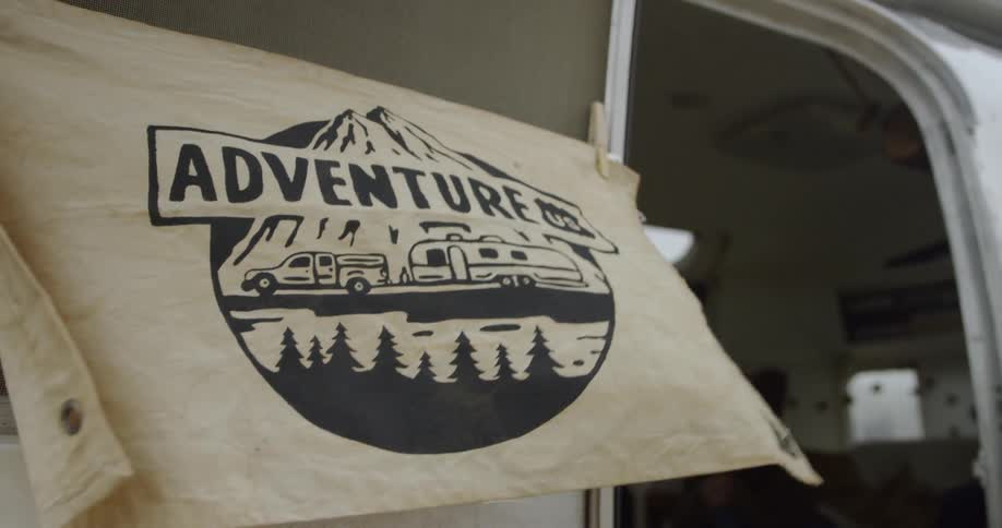 A banner hanging on a camper door blows in the wind