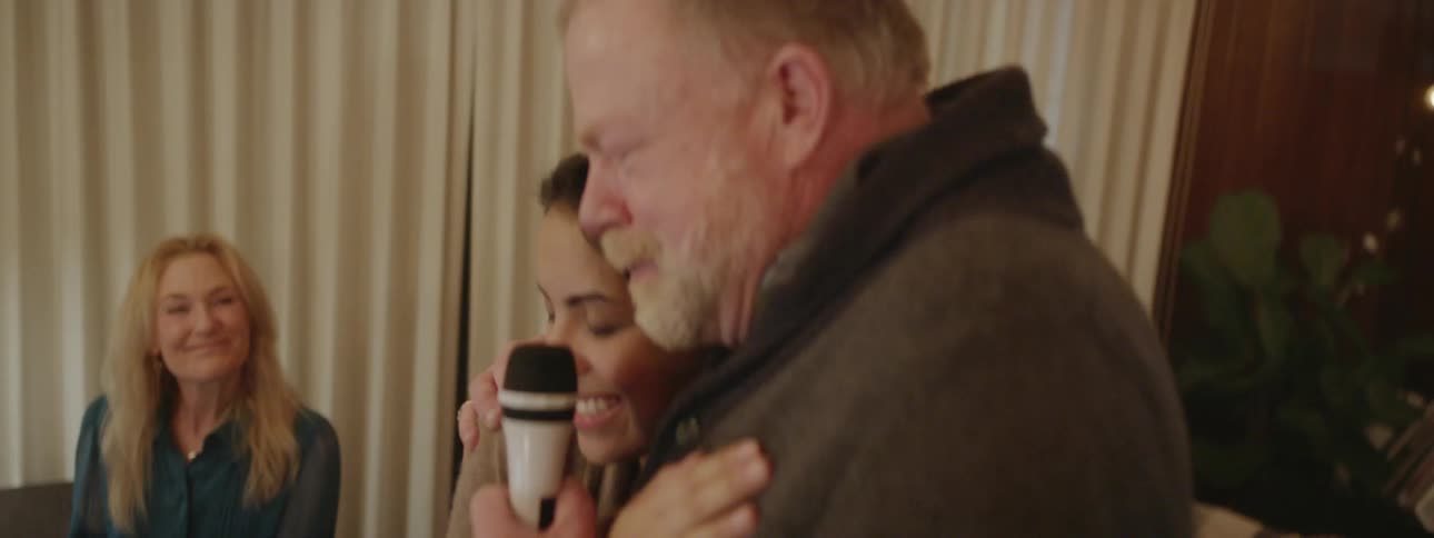 Man and woman hug while singing karaoke