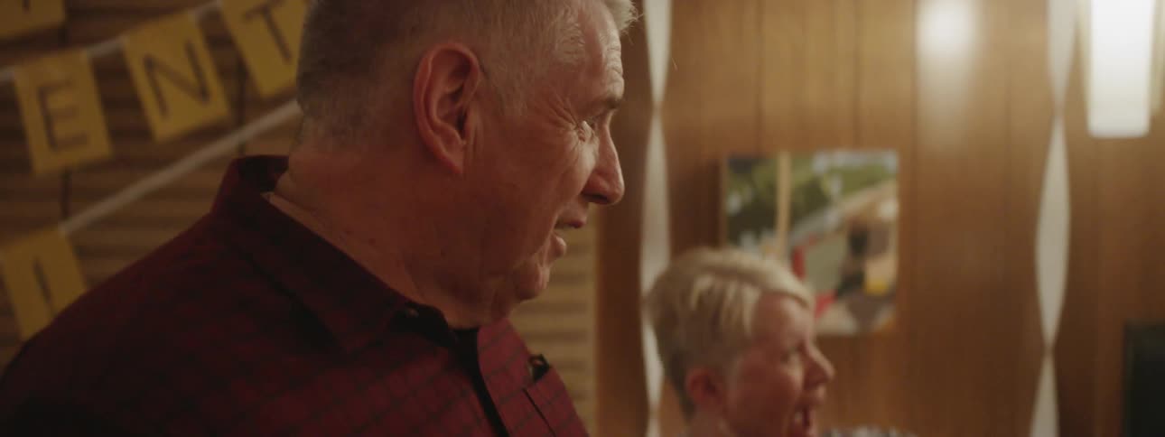 Elderly man and woman laugh and smile at a party