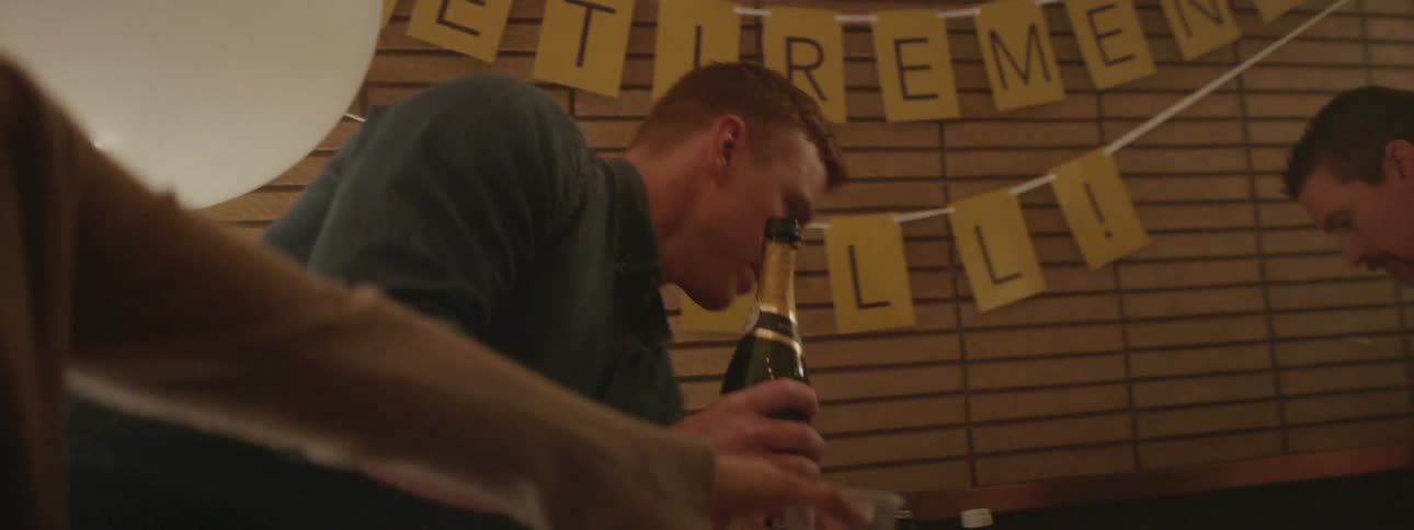 A man pours drinks for people at the party