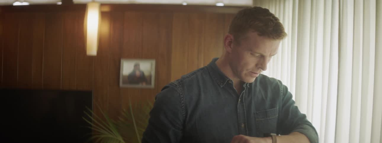 A man checks his watch and leaves the room