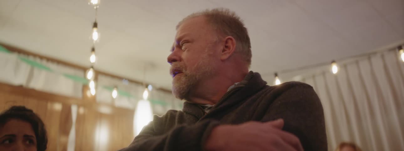 A man cries while speaking at a retirement party