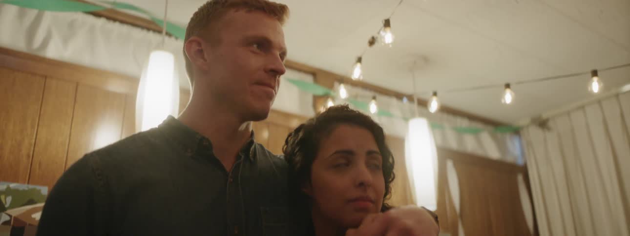 Man stands with his arm around a woman
