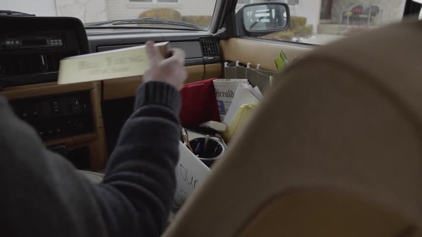 A man grabs belongings from a box