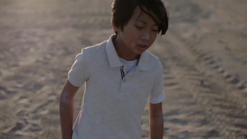 Boy walks in a dirt field