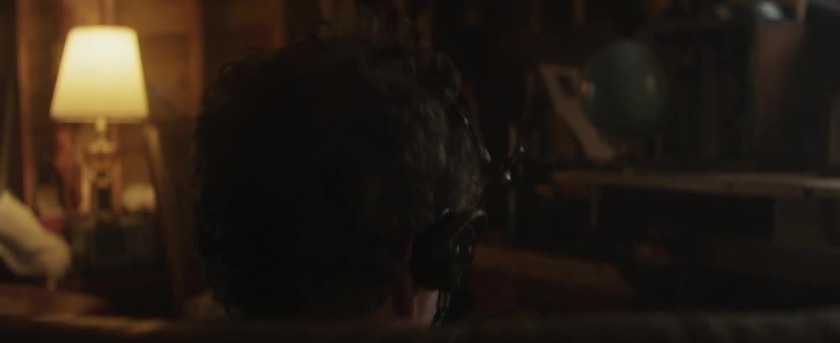 Man puts on headphones and sits on a couch