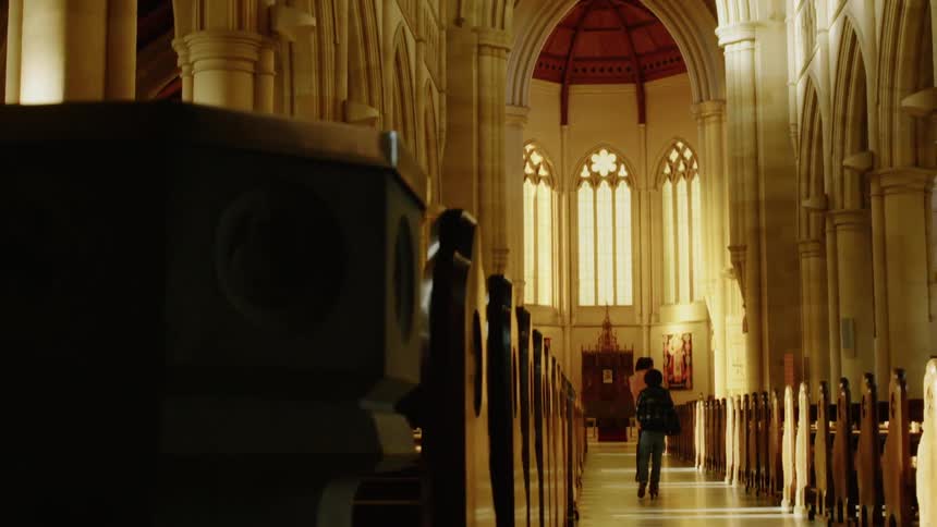 A young boy rides a scooter in a church