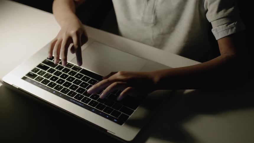 A man uses a laptop on a desk