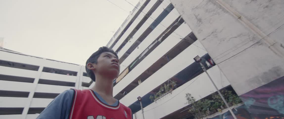Boy plays basketball on an outdoor court