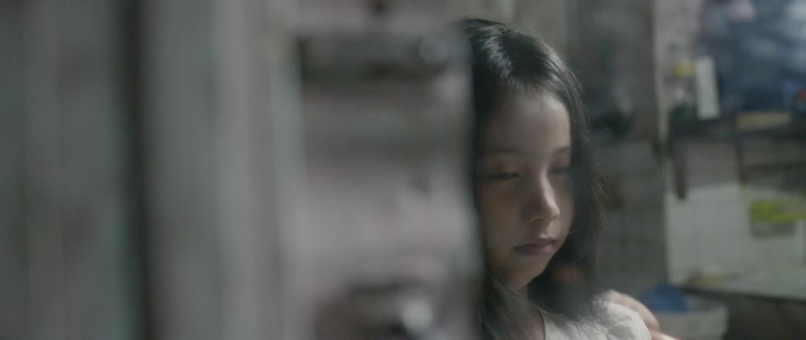 The child brushes her hair in front of the mirror