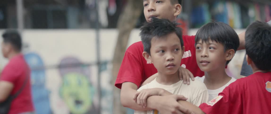 Group of boys stand with their arms around each other