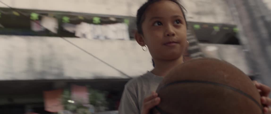 A young girl holds a basketball
