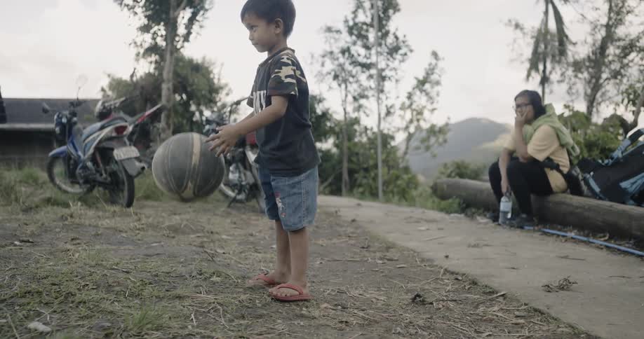 A boy is dribbling the basketball in the yard