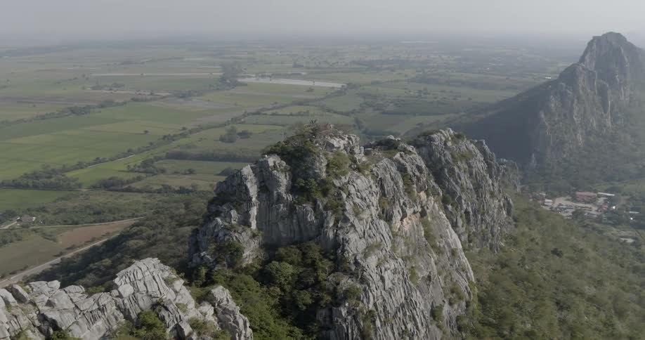 The mountain range runs in the middle of the green fields
