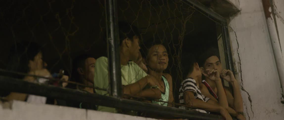 A group of people watch through a window
