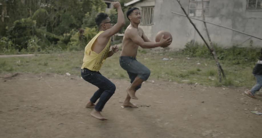 A group of young boys play basketball