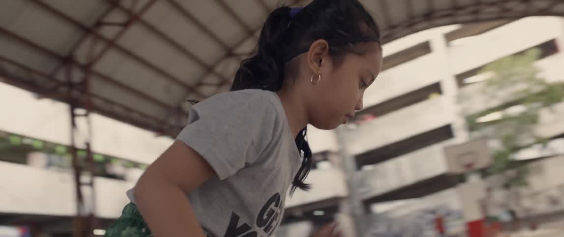 A young girl dribbles a basketball