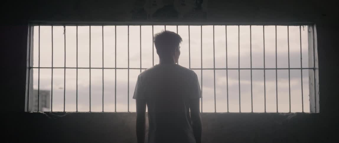 A man looks out of the bar covered window