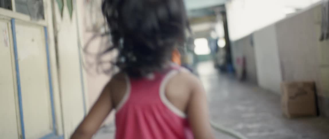 Two young girls run along an alleyway
