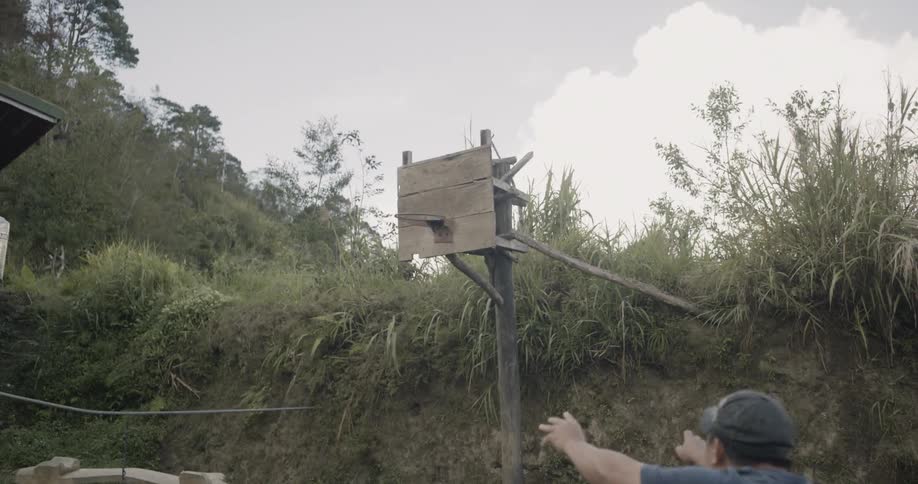 Man shoots a basketball to a homemade hoop and misses