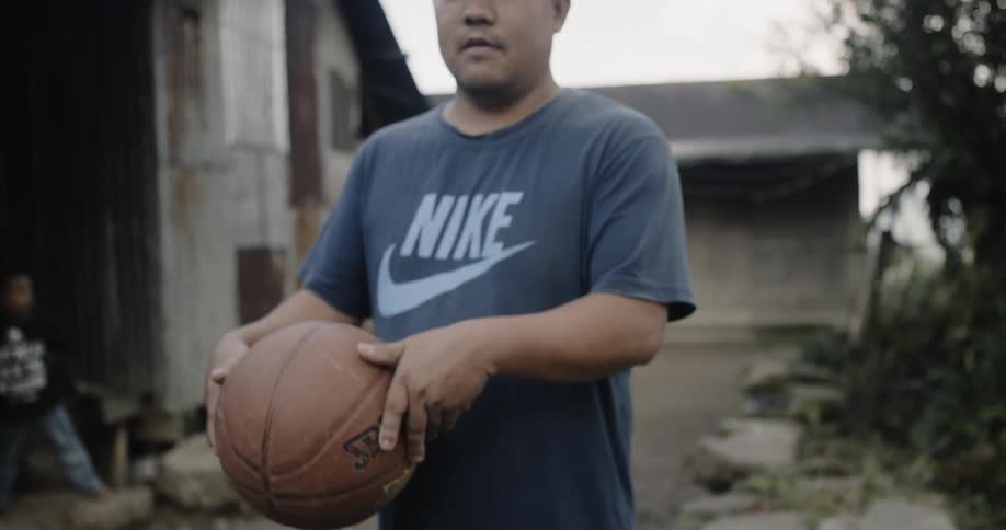A man tosses a basketball in his hands