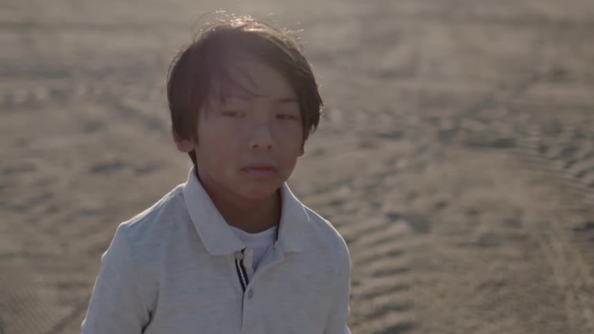 A child is on the beach on a windy day